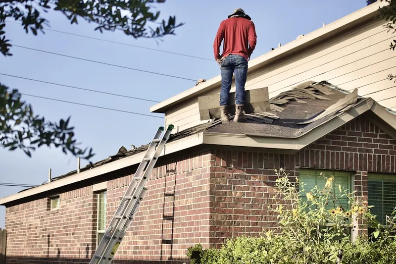 Professional roofer working on a residential roof in Hoadly